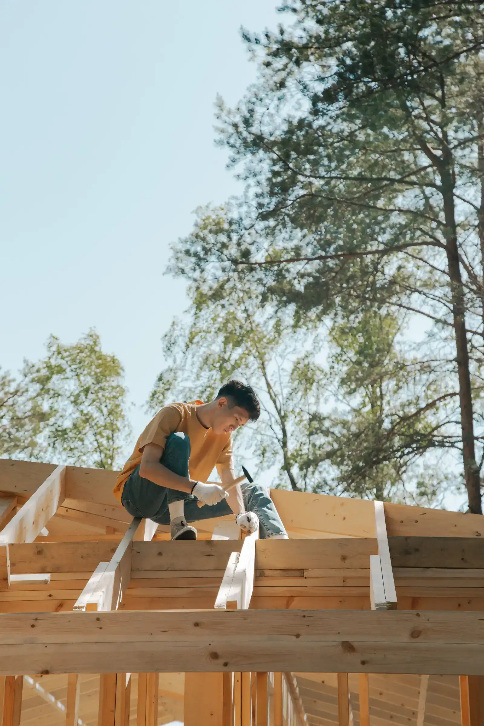 A Ridgeline carpenter working on a wooden roof frame
